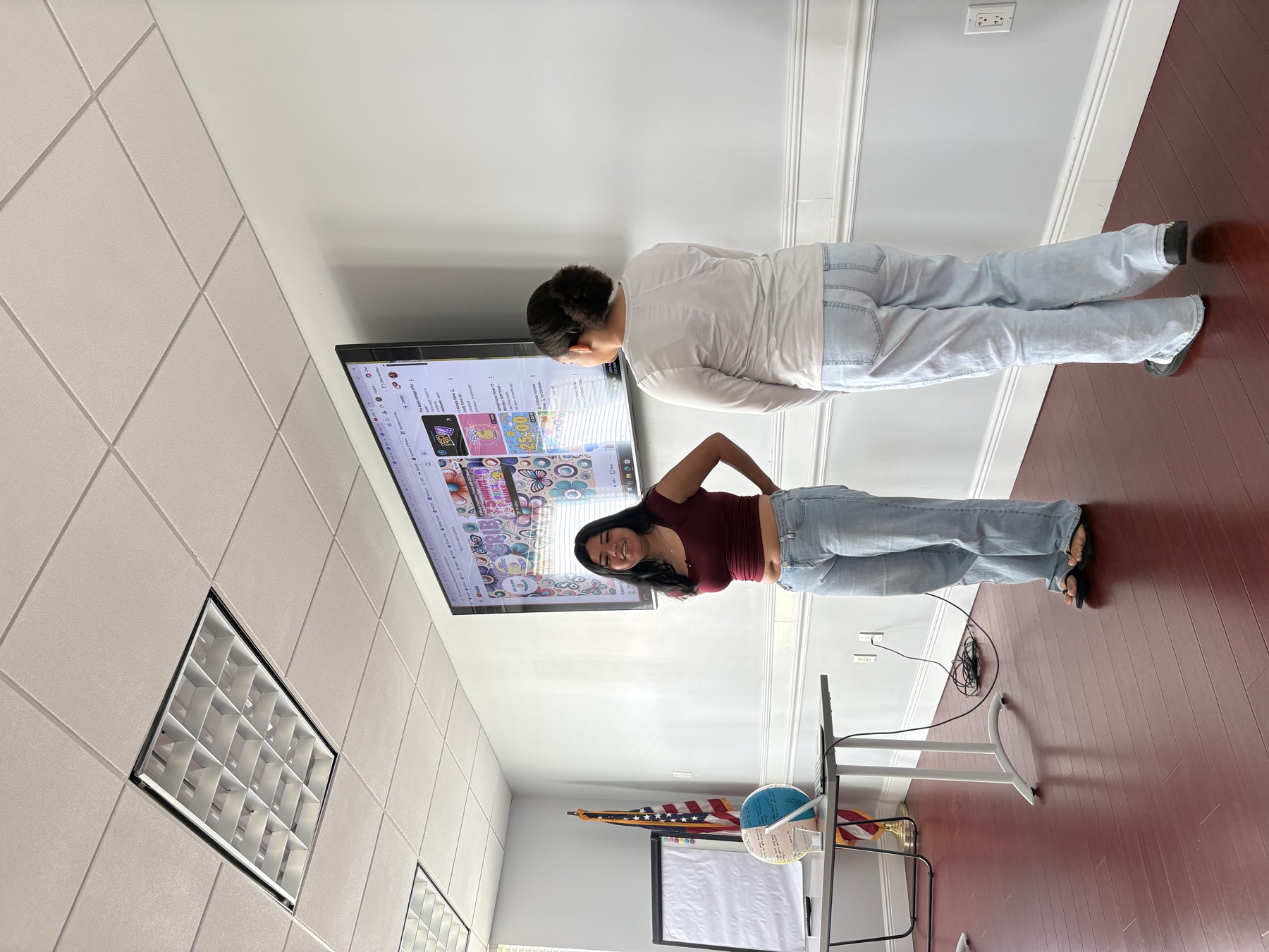 Two students standing in front of a screen presenting to the class
