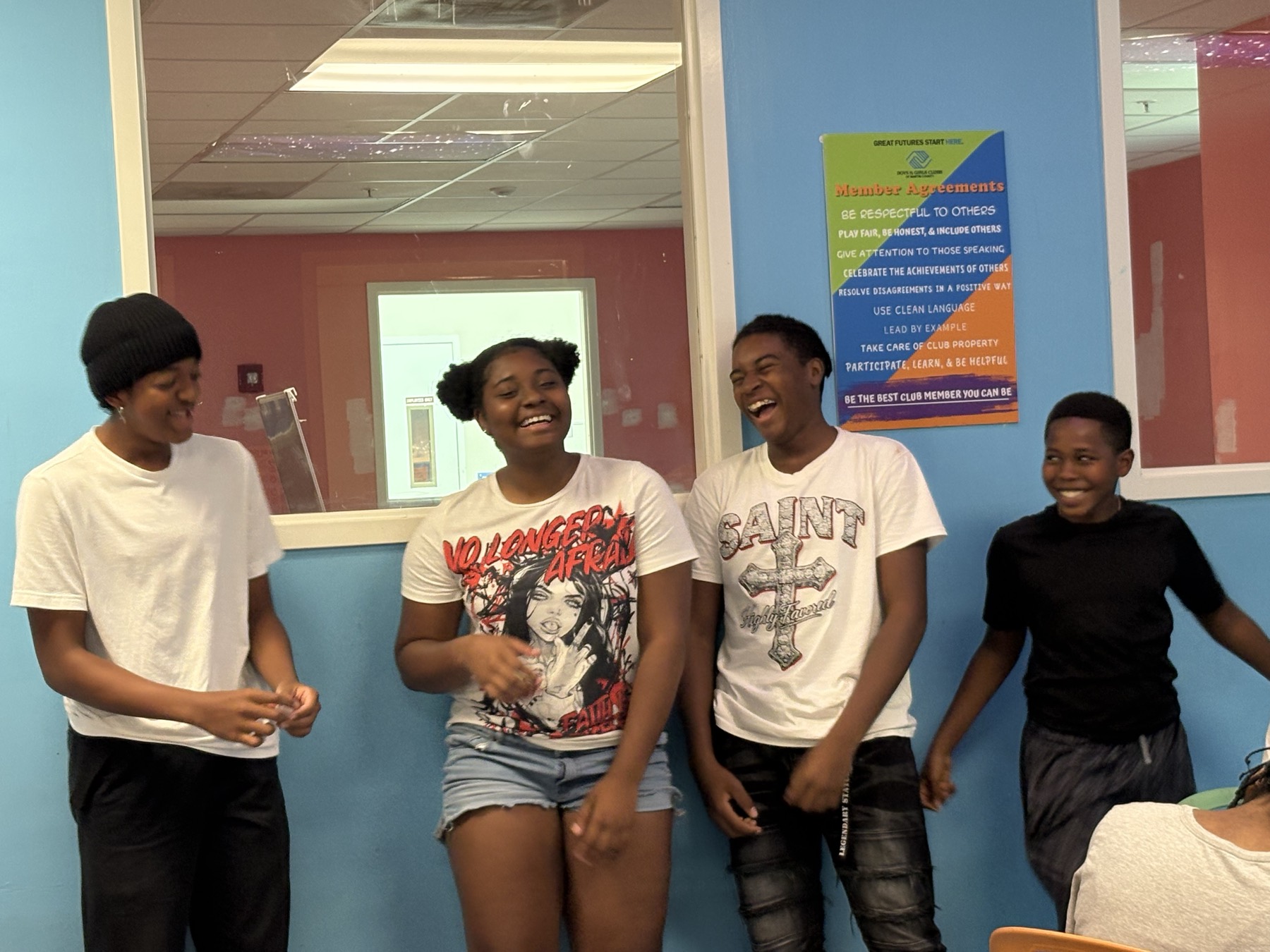 Four students laughing together during a workshop icebreaker